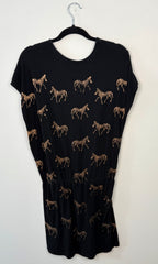 back view of black dress with zebra pattern on a hanger against a white background