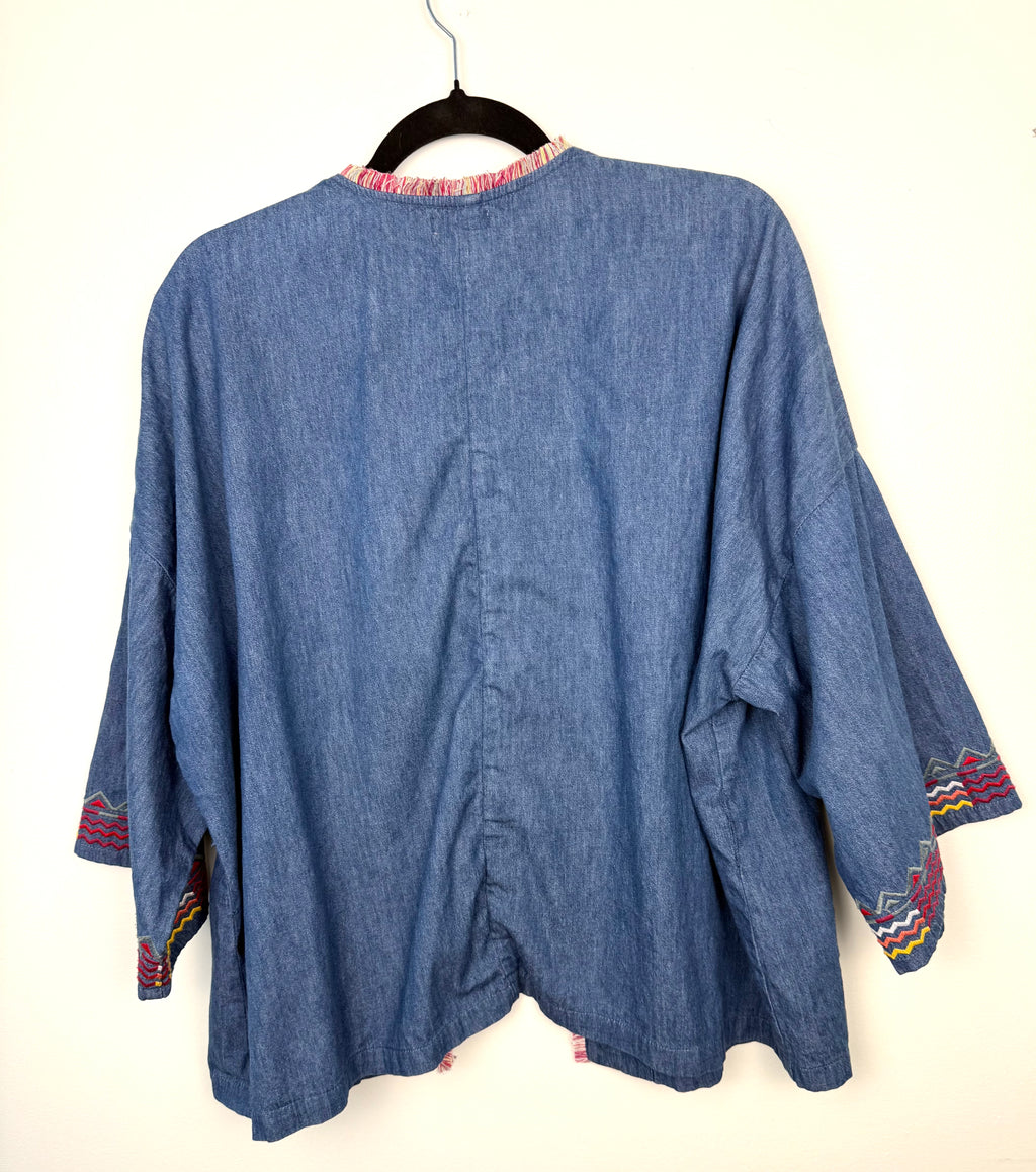 back view of lightweight chambray jacket women on hanger showing southwestern patterned cuff detail 
