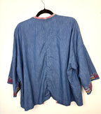 back view of lightweight chambray jacket women on hanger showing southwestern patterned cuff detail 
