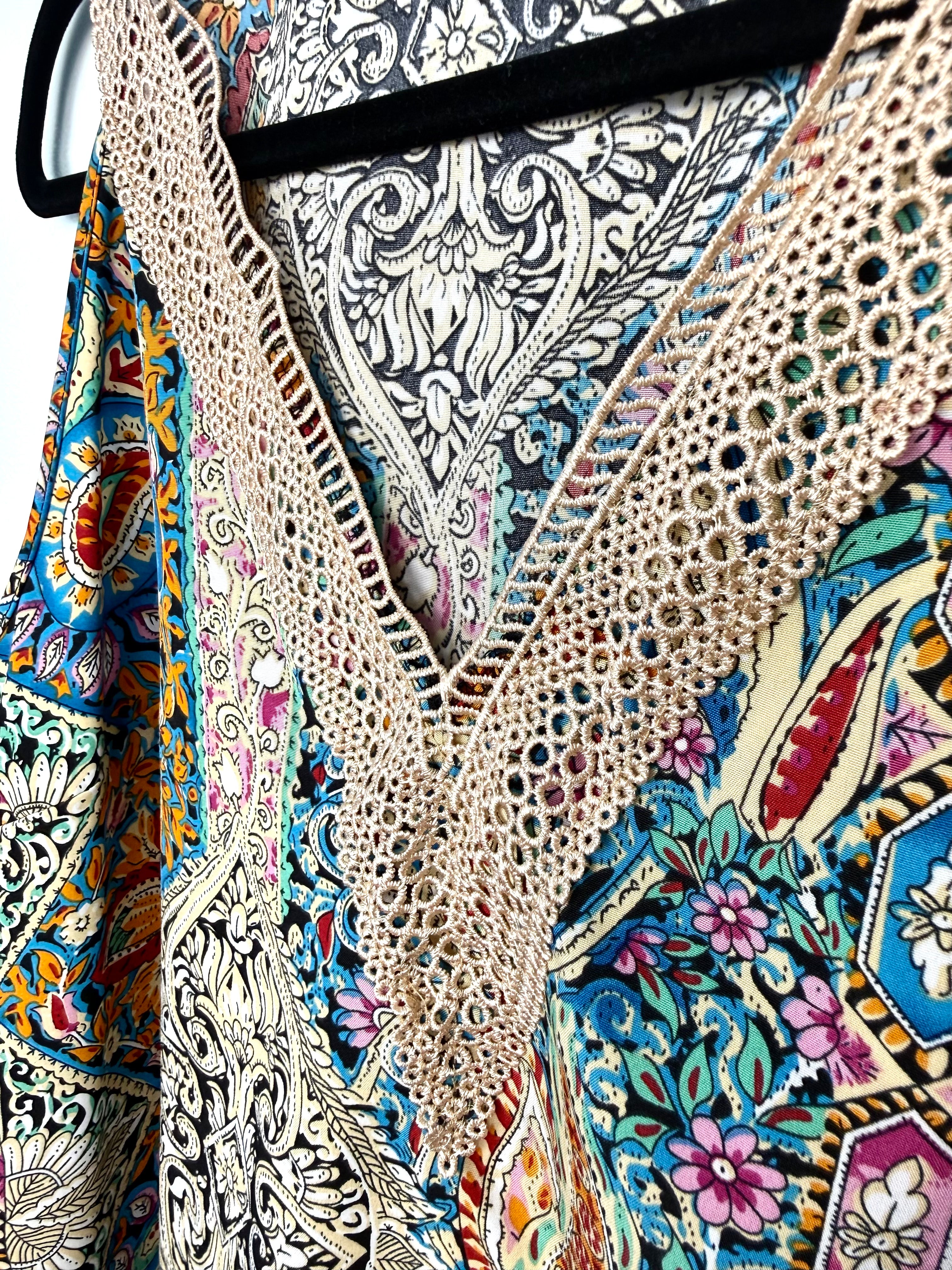 close up of crochet neckline on colourful paisley bohemian blouse with crochet lace neckline