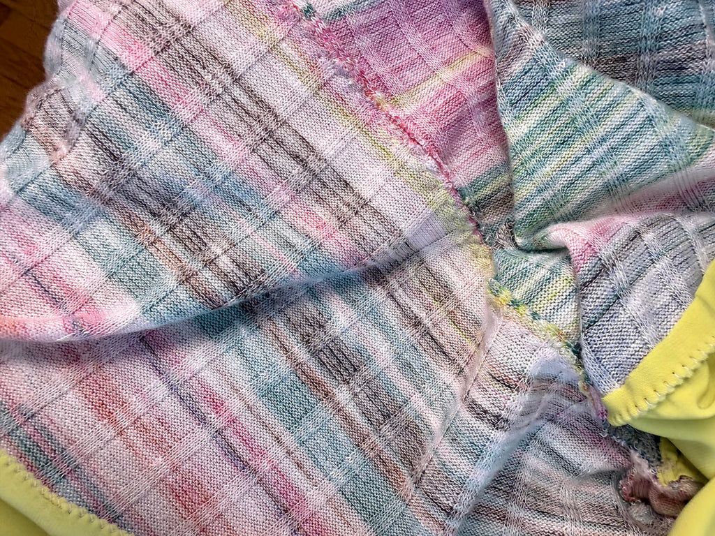 close up of hand stitching on inside of Handmade lime green draped cardigan with asymmetrical colourblock striped panel in pink and green tones