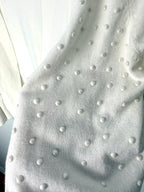 close up of pearl beading embellishment on feminine ivory cardigan sweater