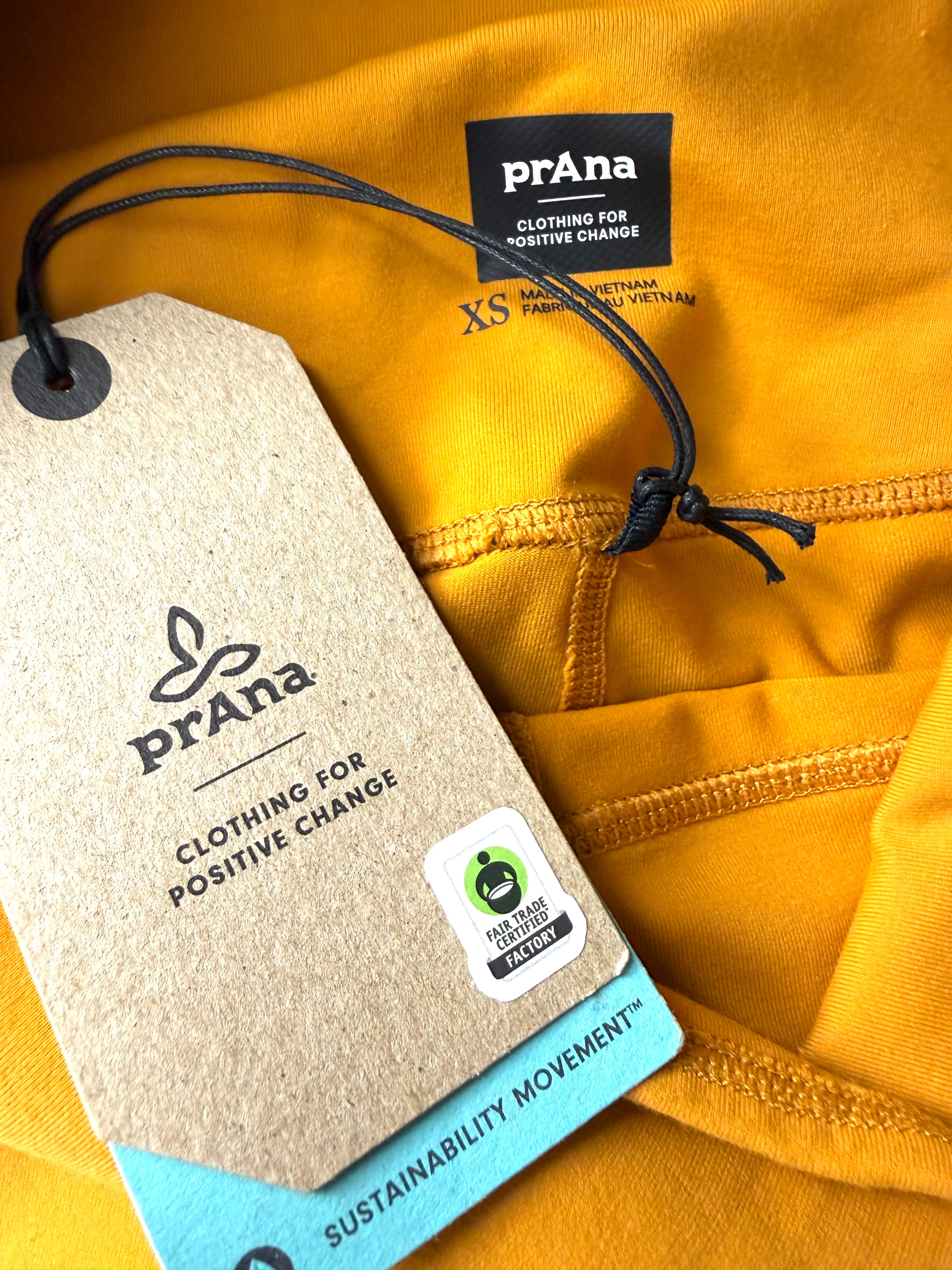 close up of sustainable tag on NWT PrAna Chakara 7/8 Leggings Deep Solstice 