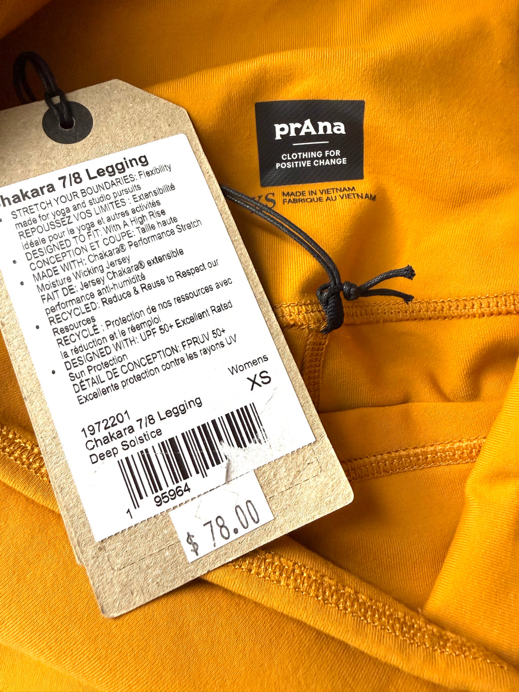 close up of sustainable tag on NWT PrAna Chakara 7/8 Leggings Deep Solstice showing $78 new price 