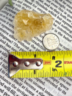 yellow fluorite with measuring tape showing it to be about 1.5"