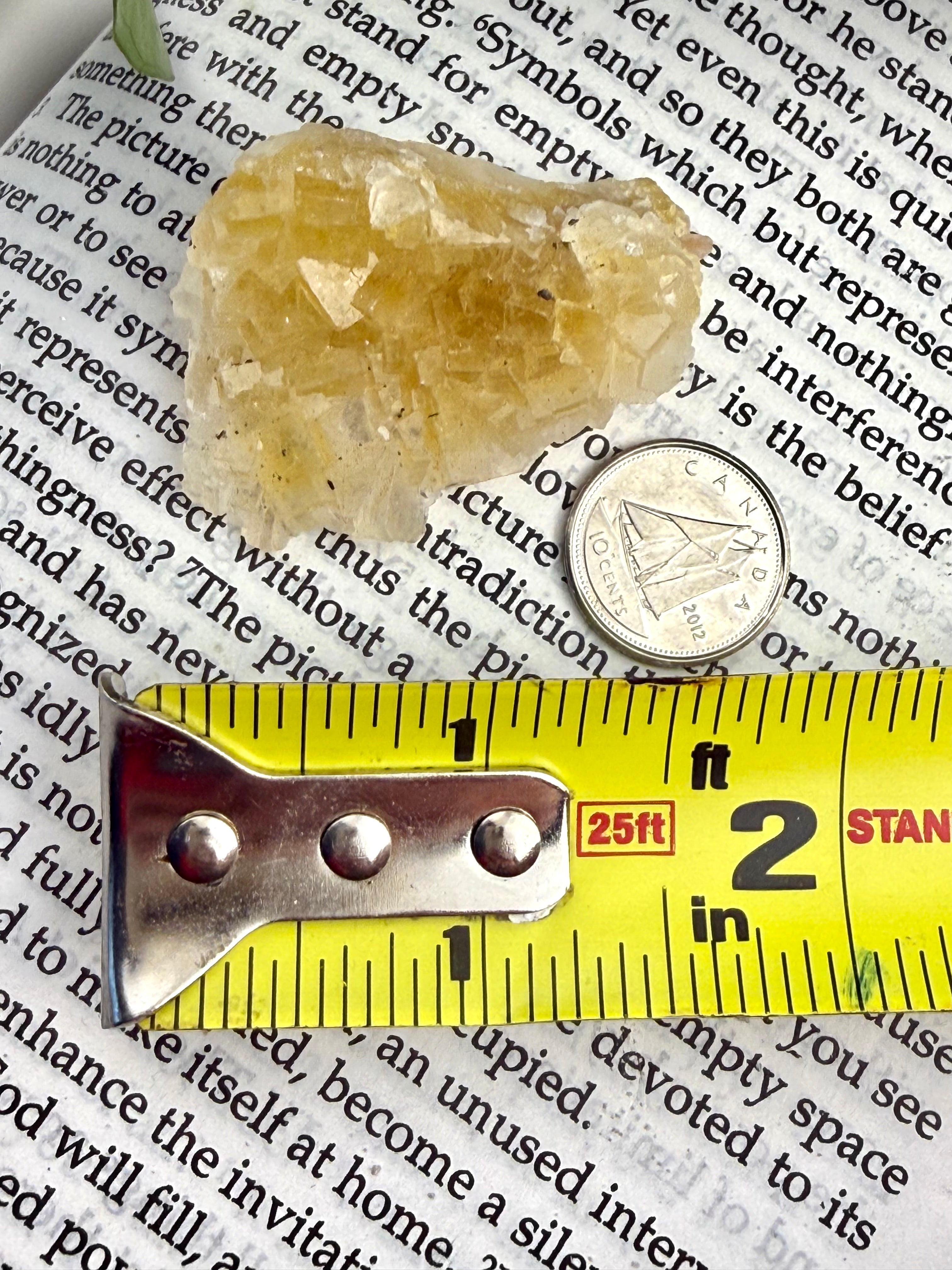 yellow fluorite with measuring tape showing it to be about 1.5"