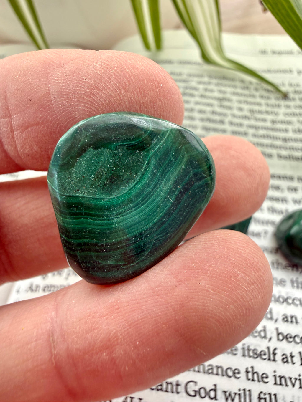 malachite stone  held between fingers on a book page