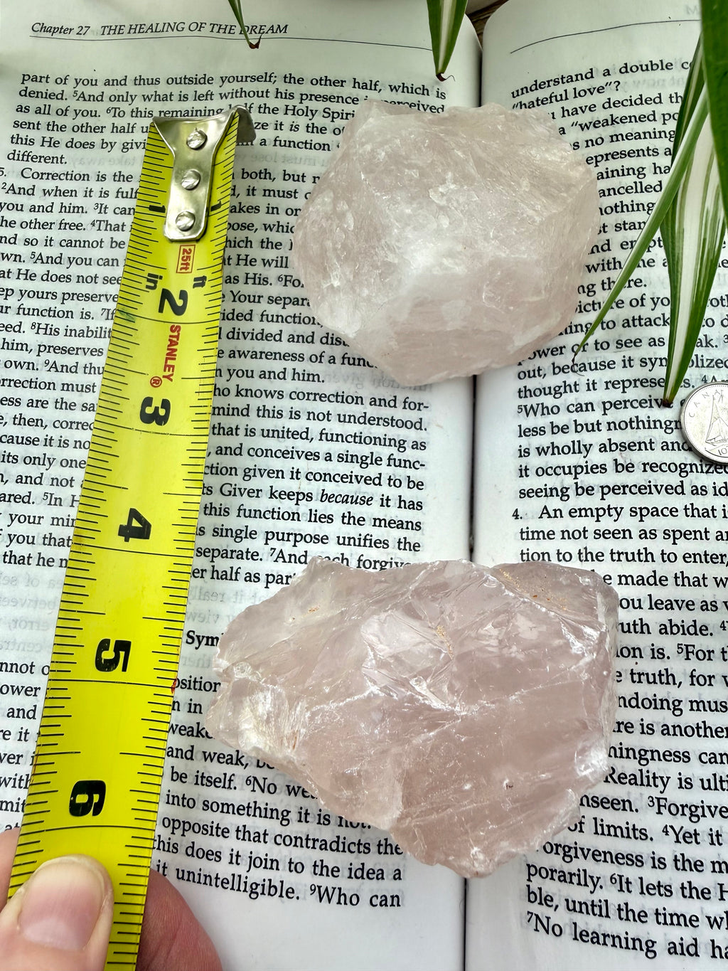 rose quartz crystals on a book with a measuring tape