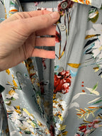 Hand holding a folded fabric with floral pattern on a matching fabric background