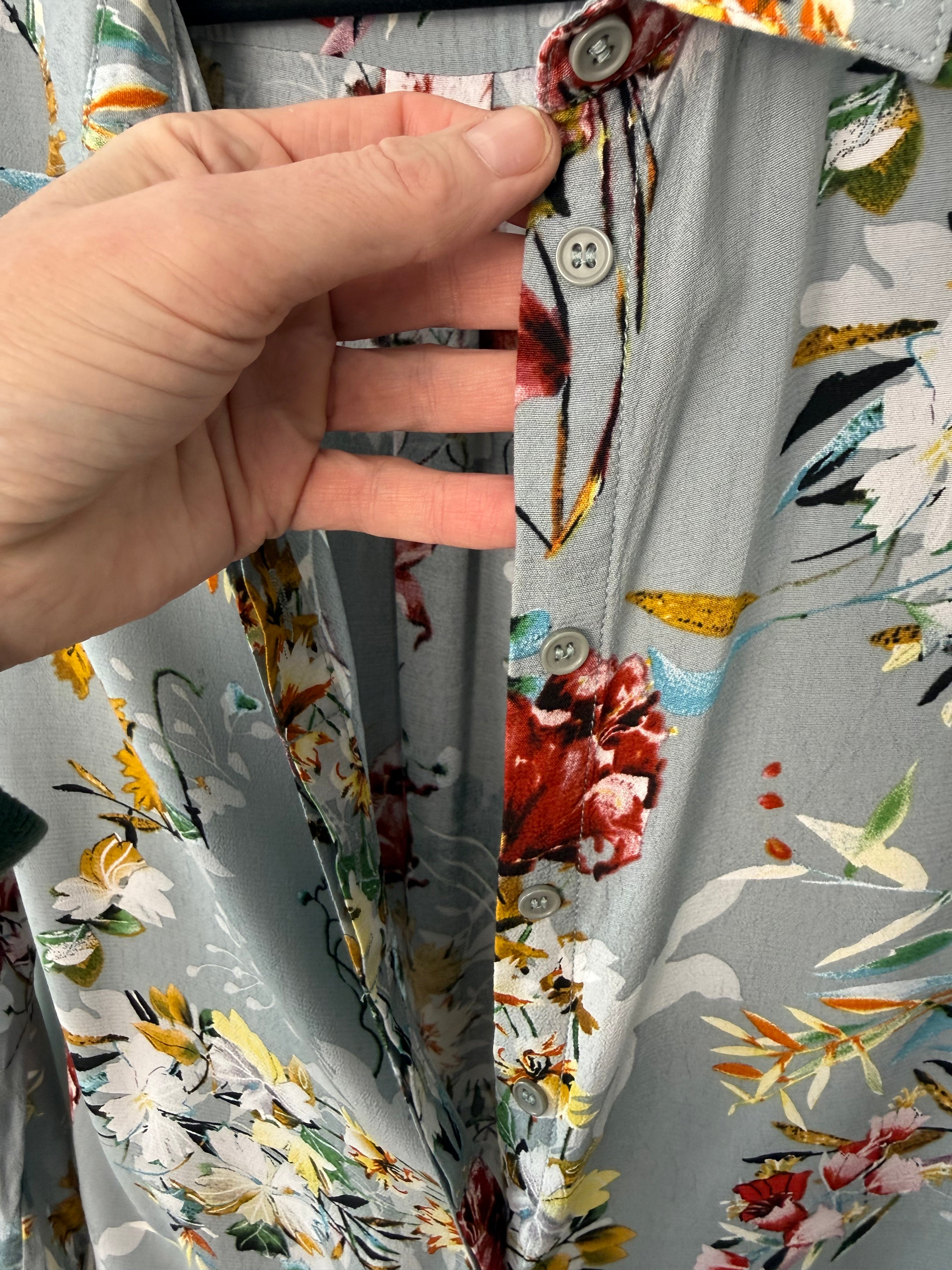 Hand holding a folded fabric with floral pattern on a matching fabric background