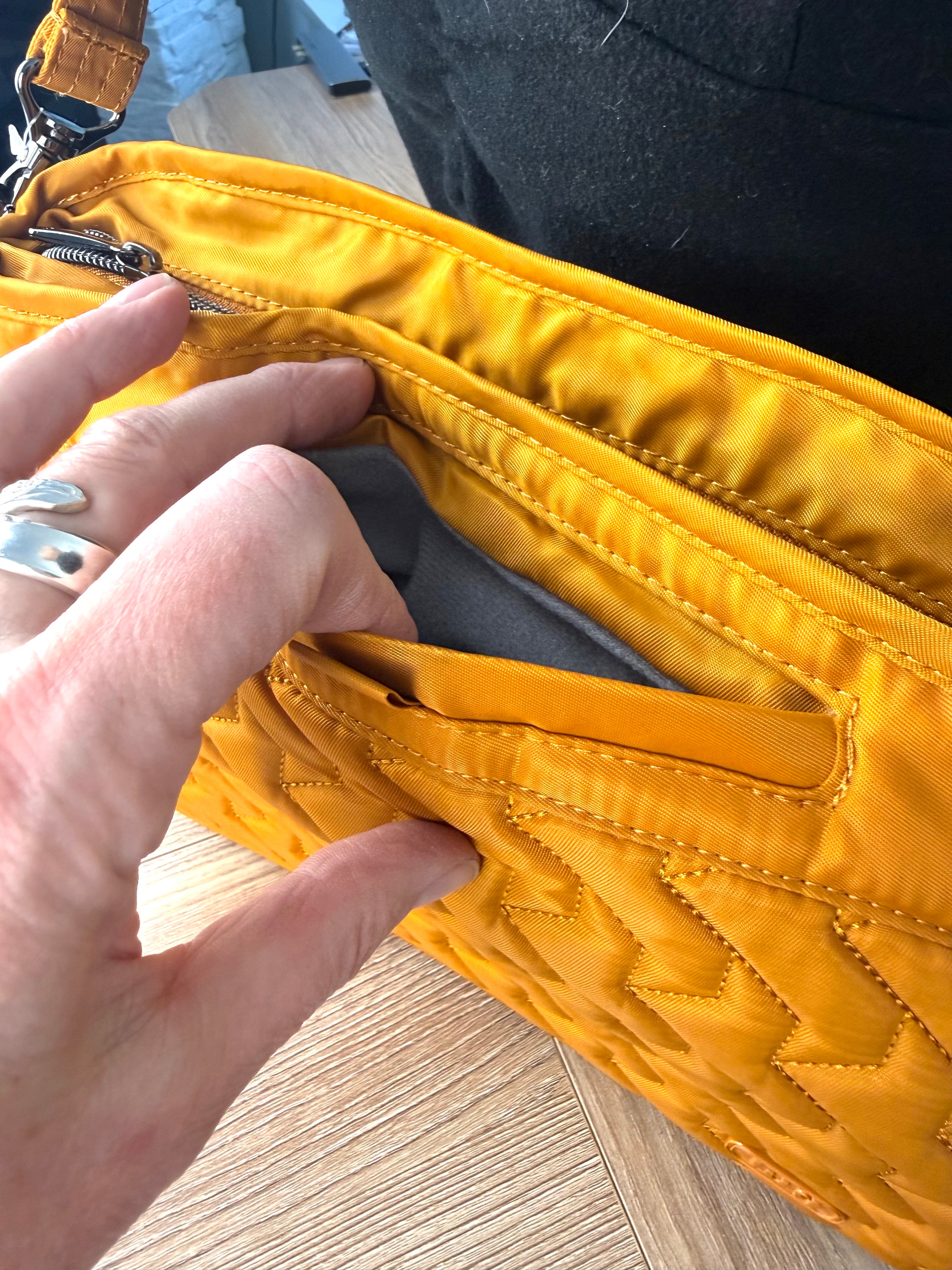 front phone pocket on Retired Lug Wings Travel Cross Body Bag in mustard yellow.