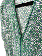 green v neck blouse with blue trim detail geometric print women’s top close up of pattern