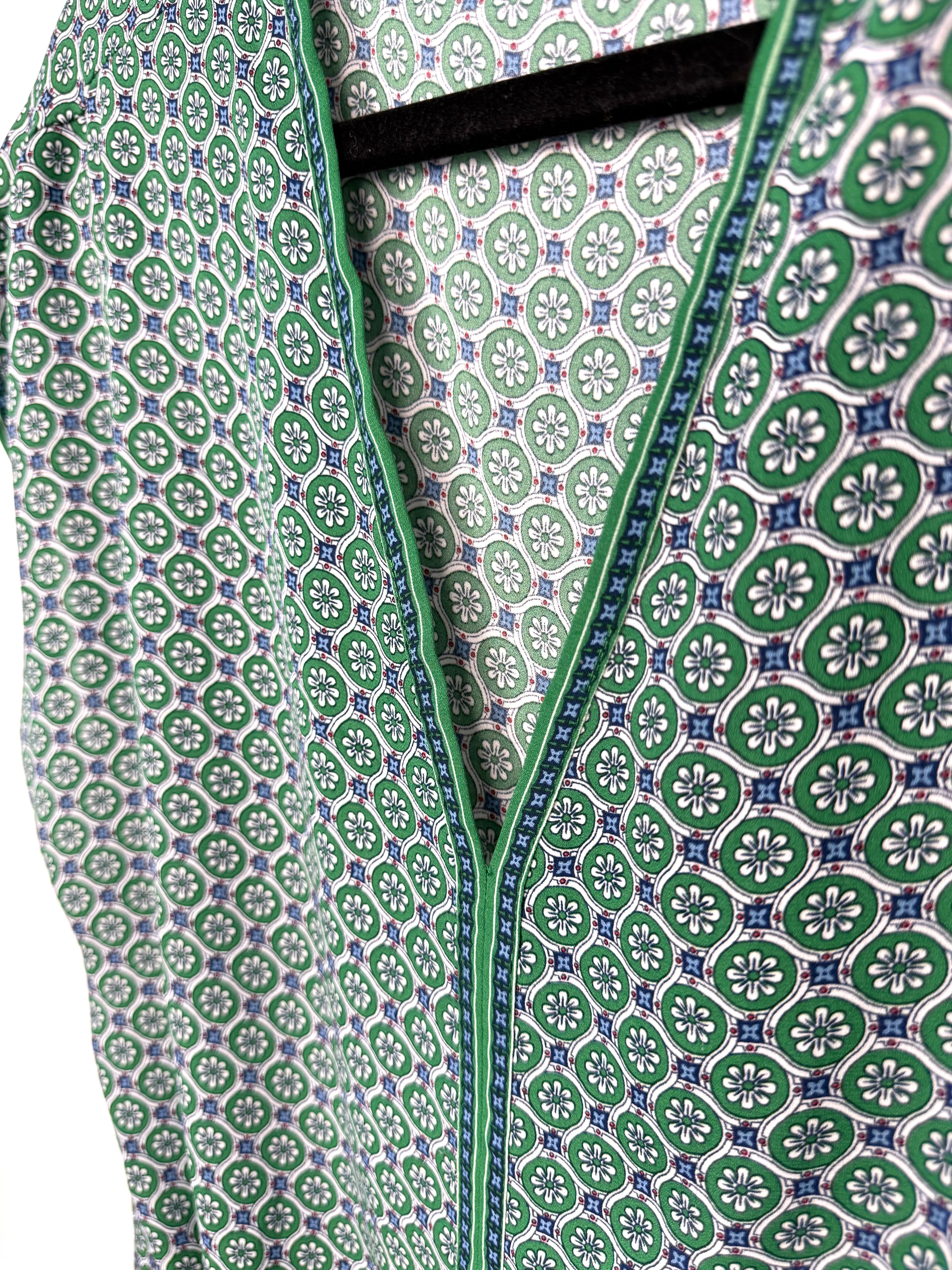 green v neck blouse with blue trim detail geometric print women’s top close up of pattern