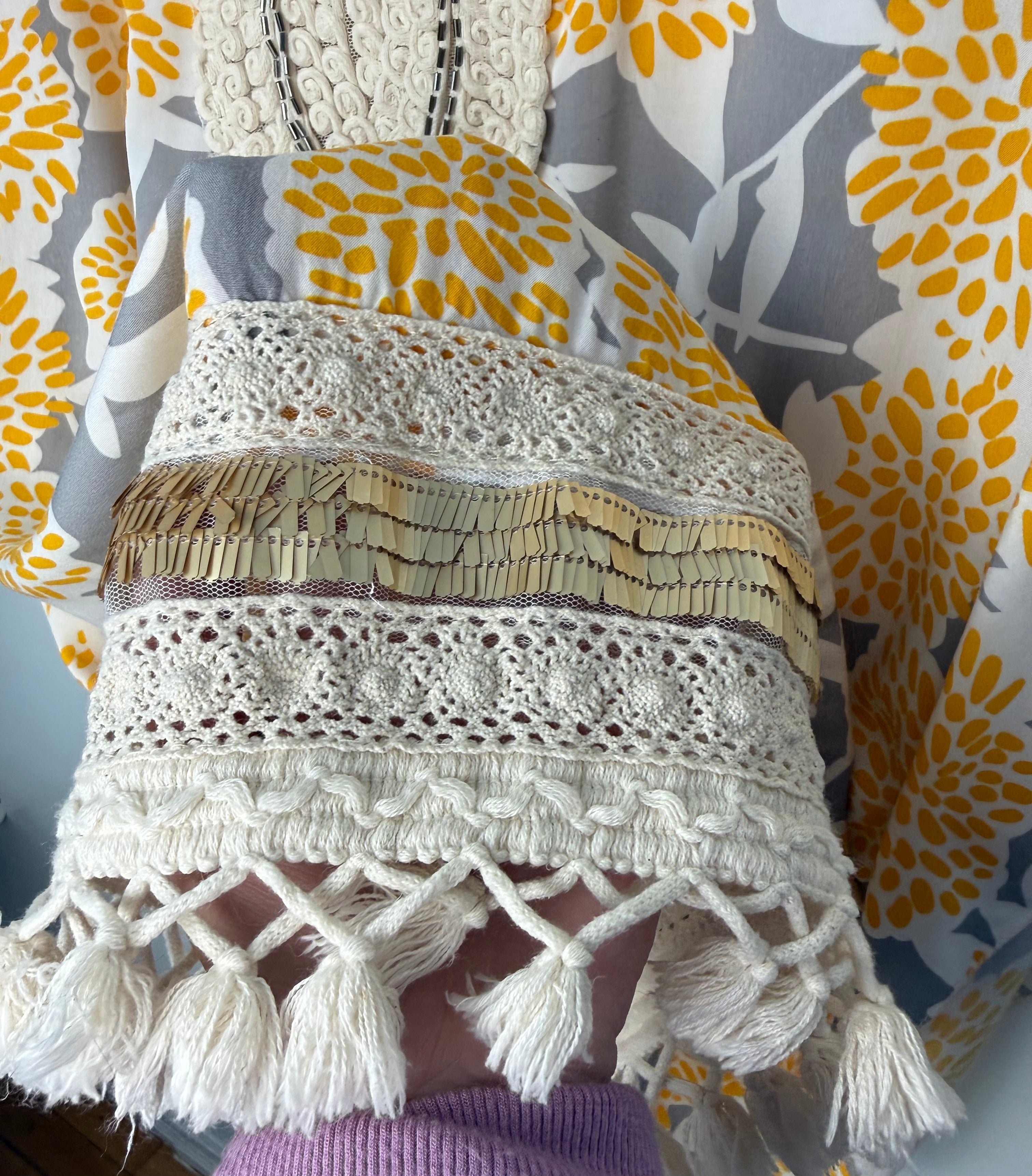 hem detail on Made in Italy Boho floral kaftan top with yellow and cream print, crochet V neckline, and tassel hem, lightweight Italian viscose blouse