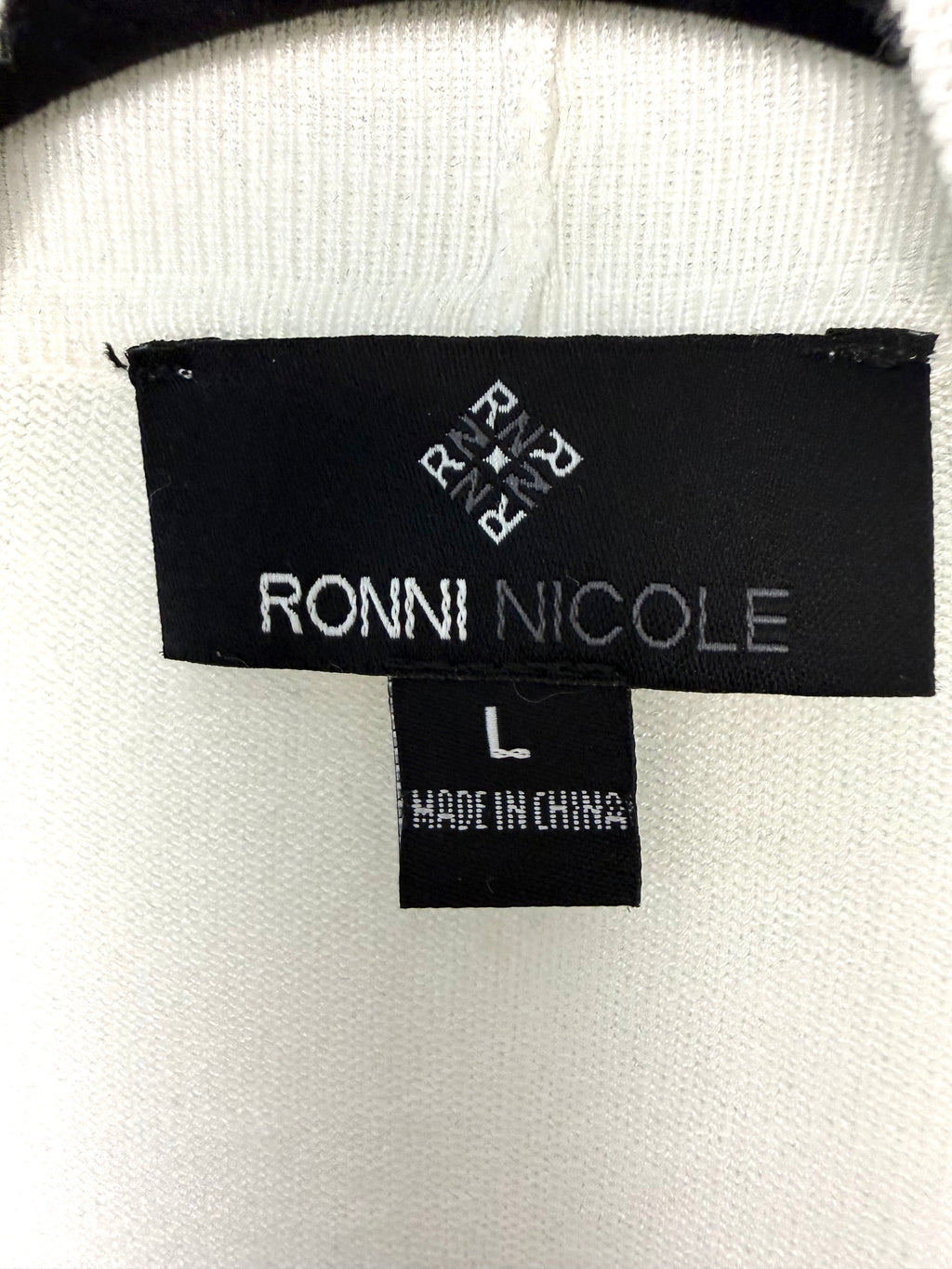 inside hang tag on vory cropped open front cardigan, dressy layering piece for dresses and skirts says Ronni Nicole brand size L made in china 