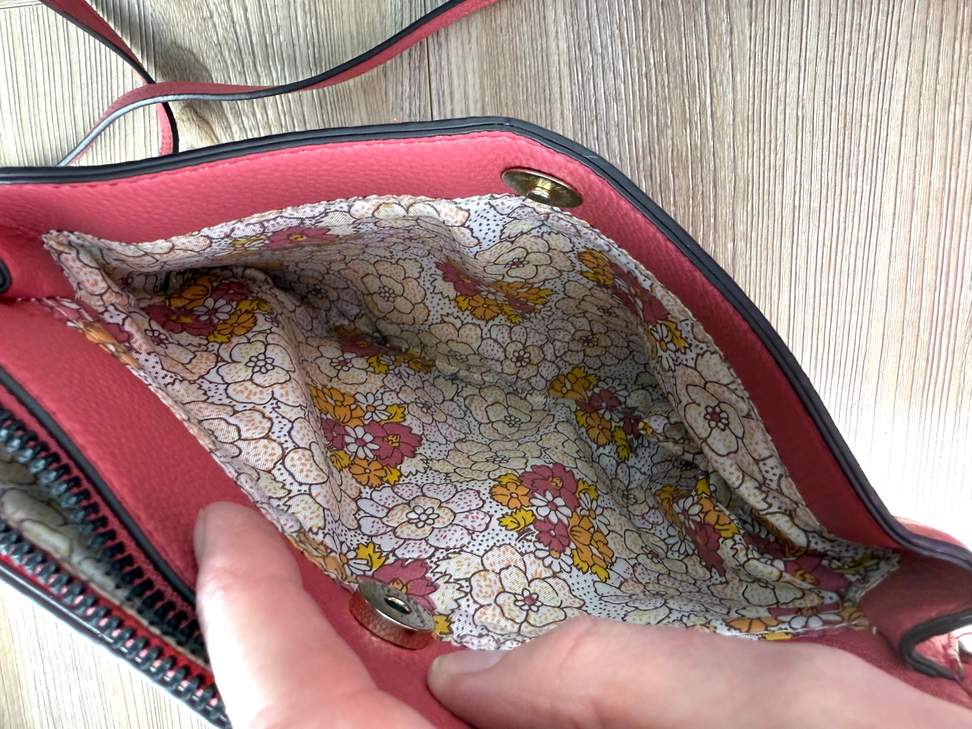 inside of front pocket on Nanette Lepore Pink Pebbled Leather Crossbody Bag at Blue Sparrow Shop 