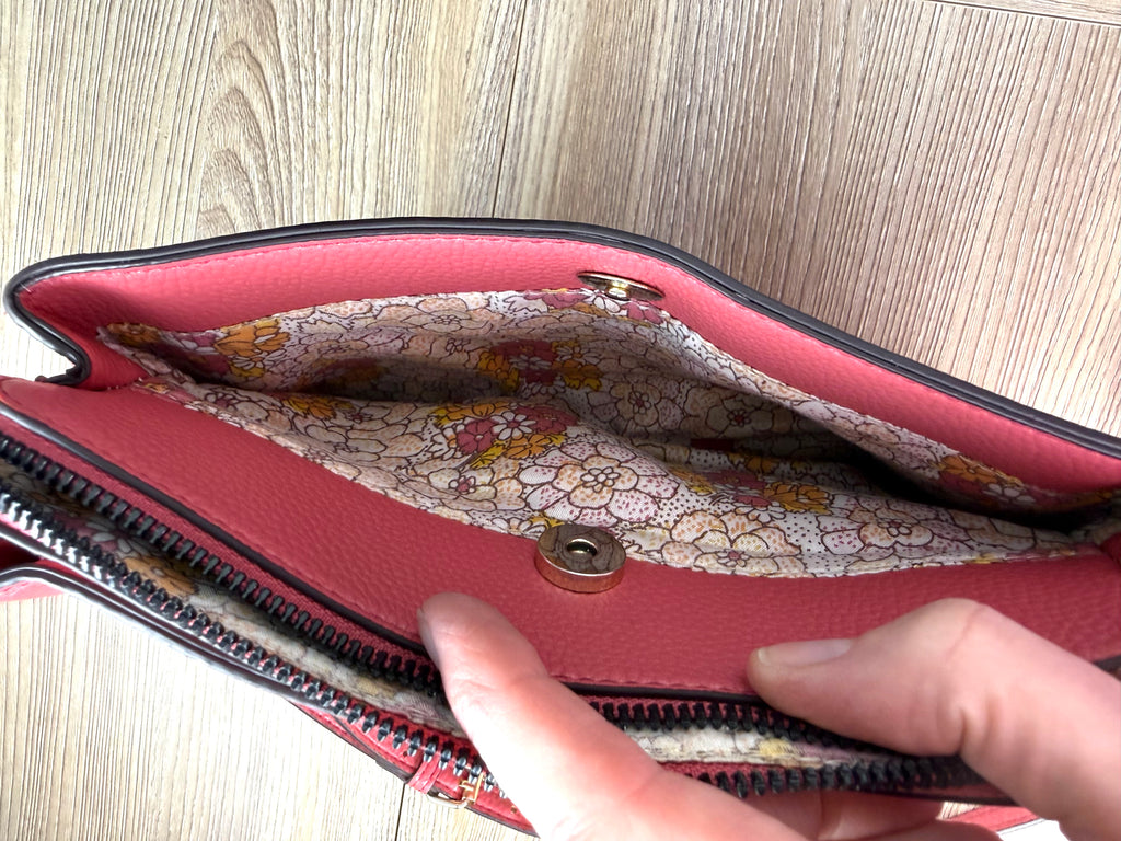 inside of front pocket on Nanette Lepore Pink Pebbled Leather Crossbody Bag at Blue Sparrow Shop 