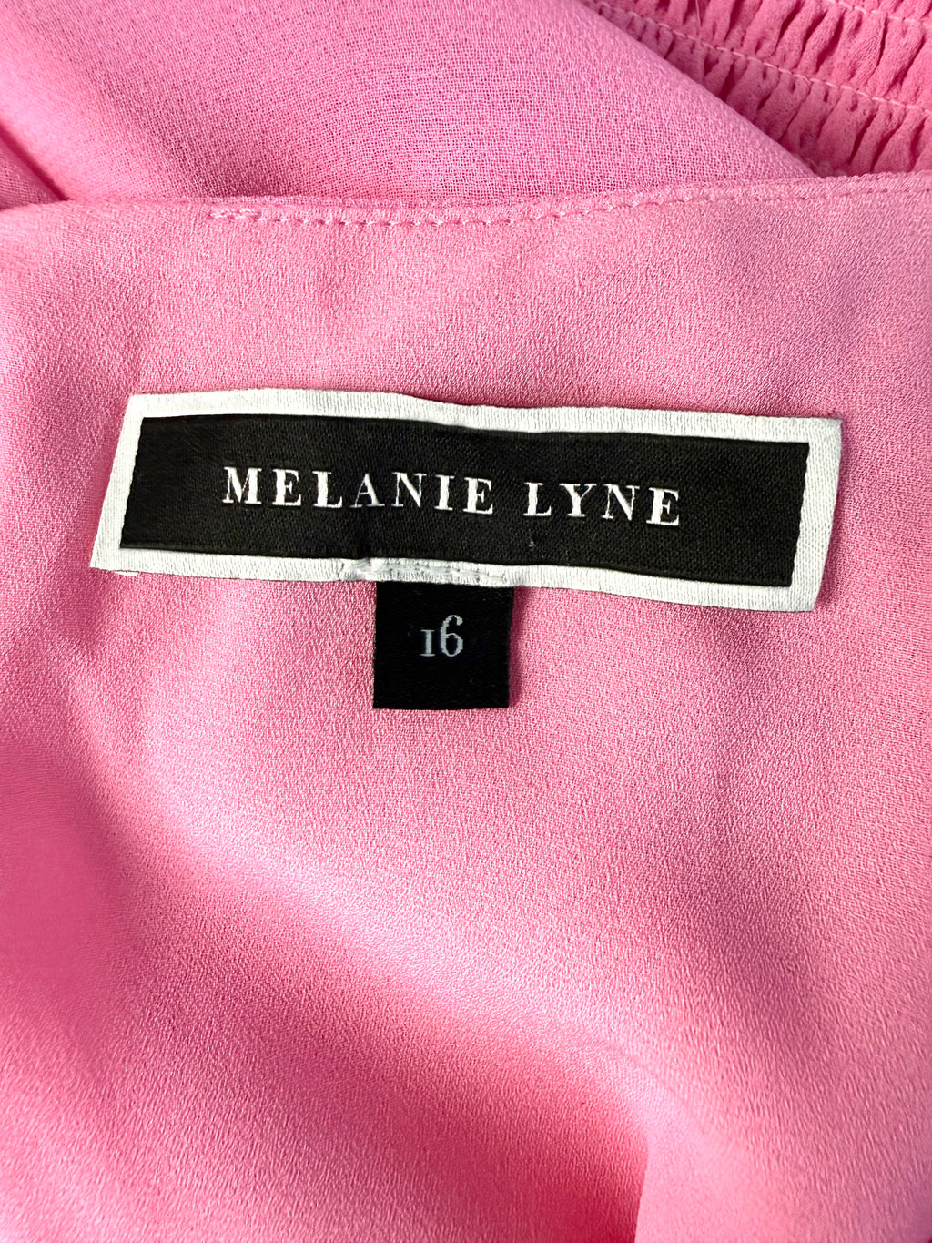 inside tag Melanie Lyne pink chiffon blouse with smocked waist and flutter sleeves
