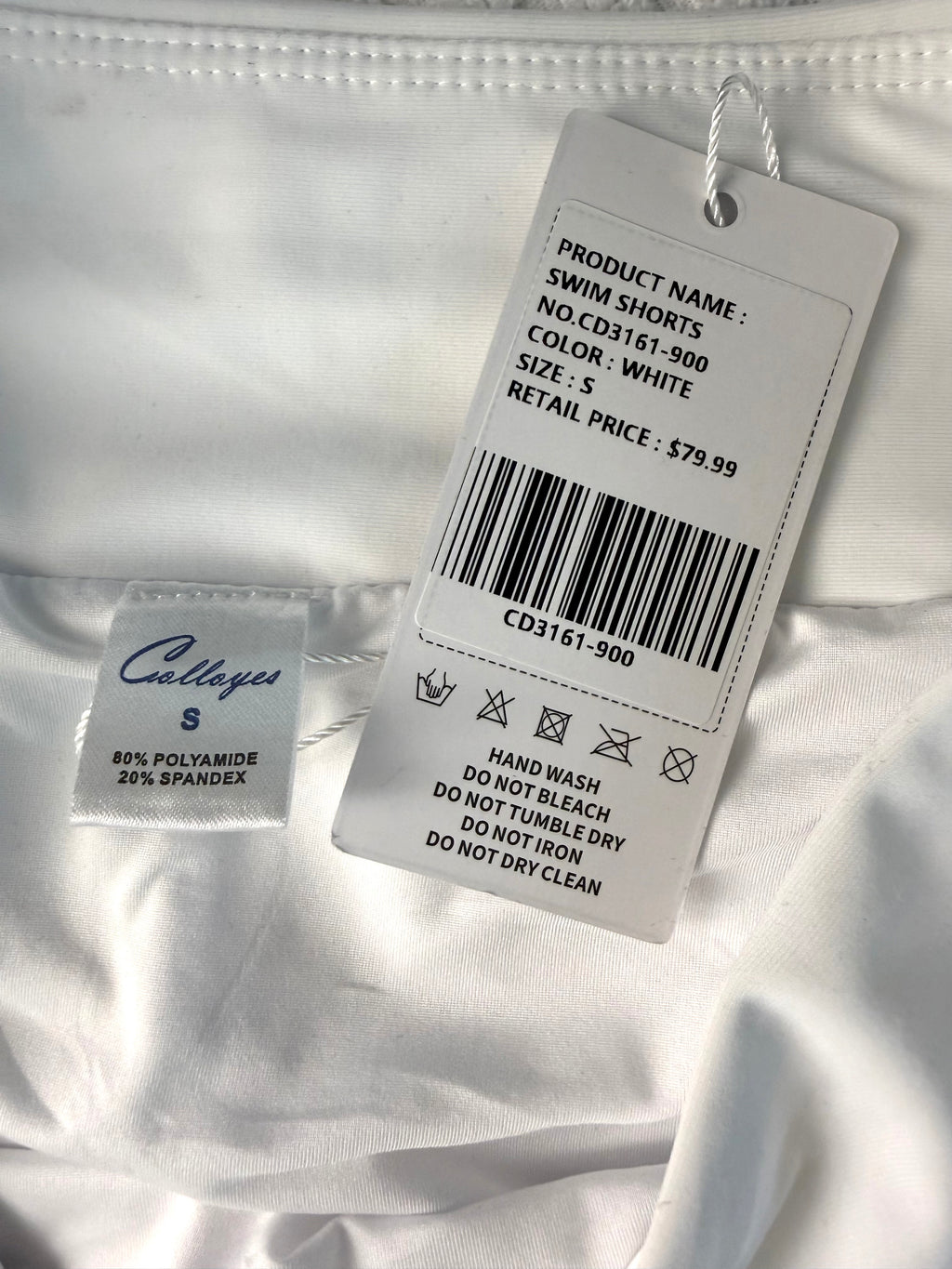 inside tag and original price tag on NWT white swim trunks size small compare at 79.99 at Blue Sparrow Resale Shop 