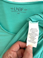 inside tags on Leave Nothing But Footprints Bamboo Tee | Size M in tiffany blue  showing 95% viscose from bamboo 