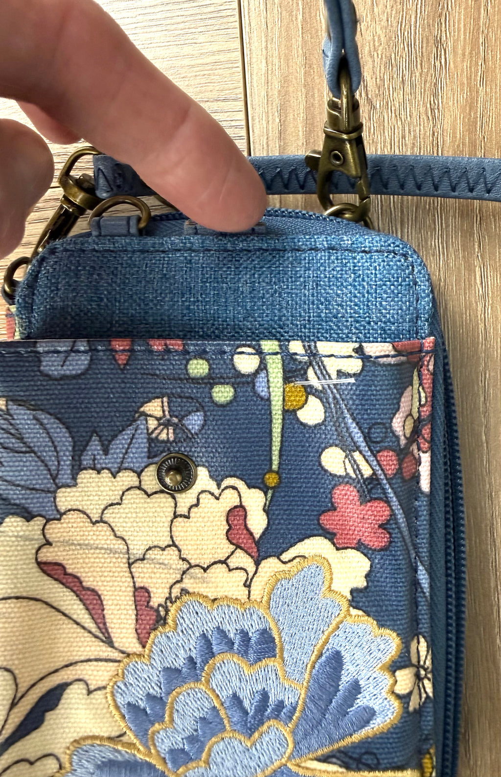 missing strap on Sakroots Floral Crossbody Phone Wallet  showing inside paper money section, cards and zipper 