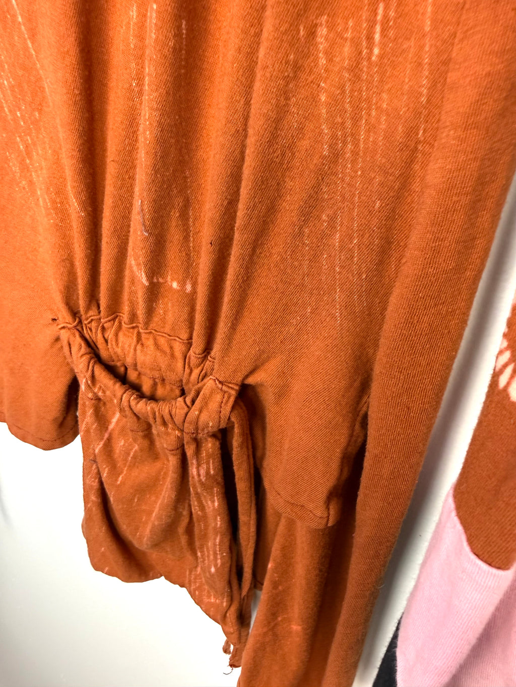 pocket detail on front of Tye dye boho artsy unique asymmetrical top in burnt orange  