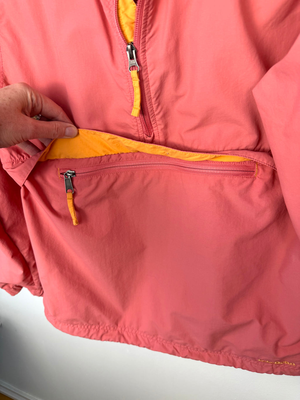 pouch on the front of LL Bean anorak jacket in coral and orange 