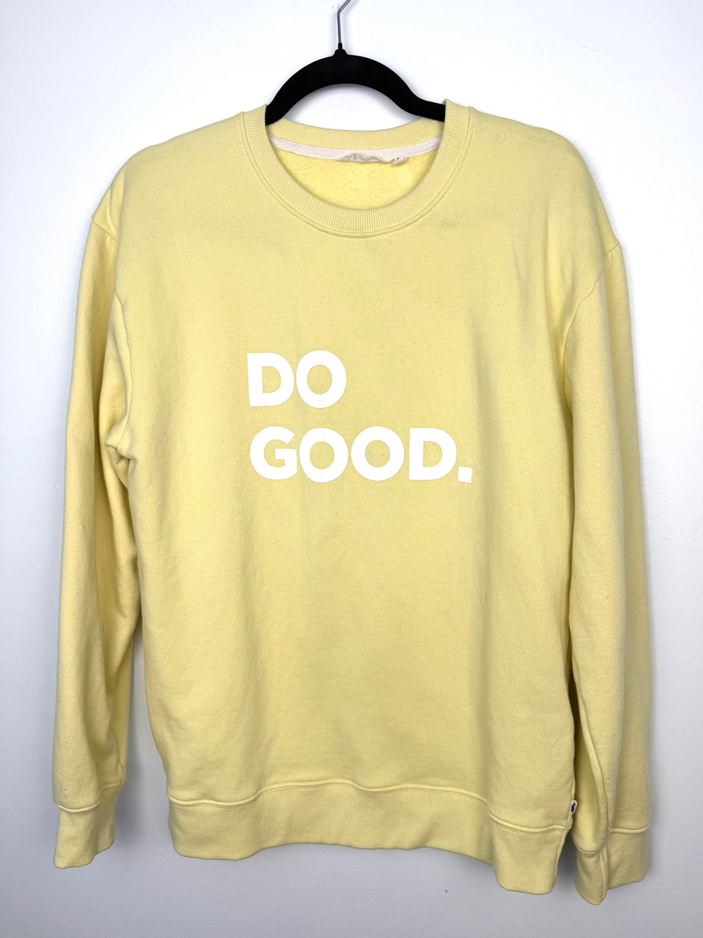 front view Cotopaxi pastel yellow crewneck sweatshirt with white “DO GOOD.” graphic.