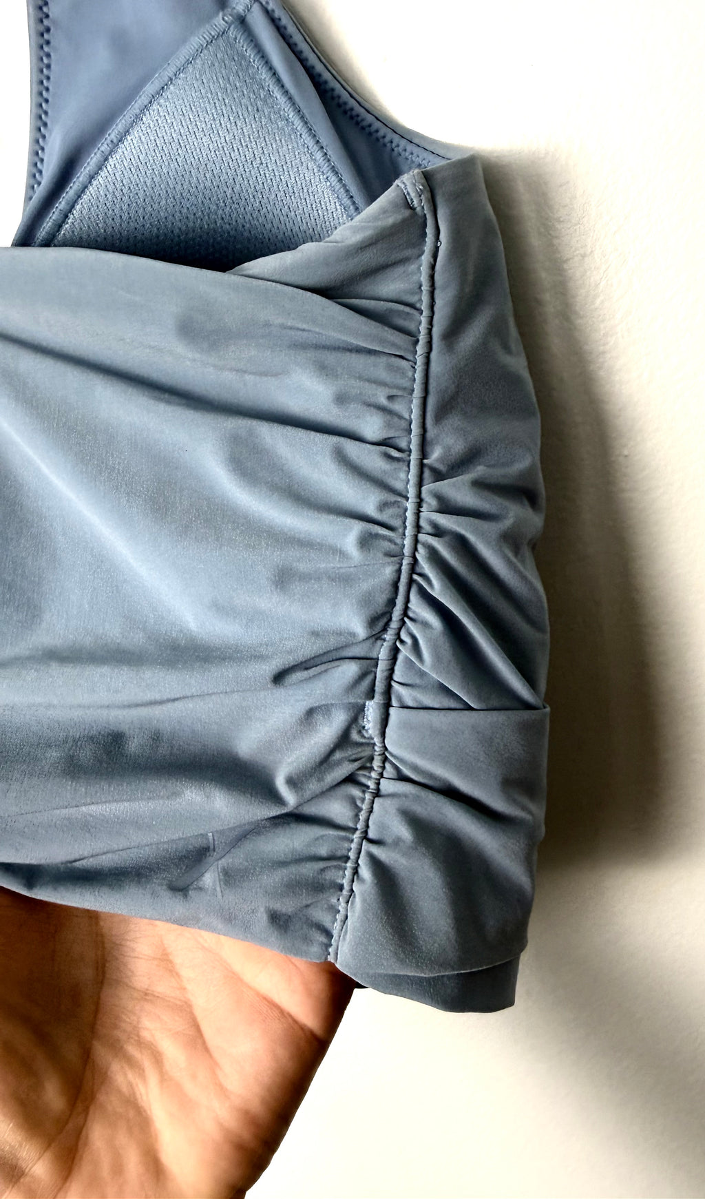 side view of Knix Blue Wrap Front Sports Bra Top | Cross Back | Size L on hanger