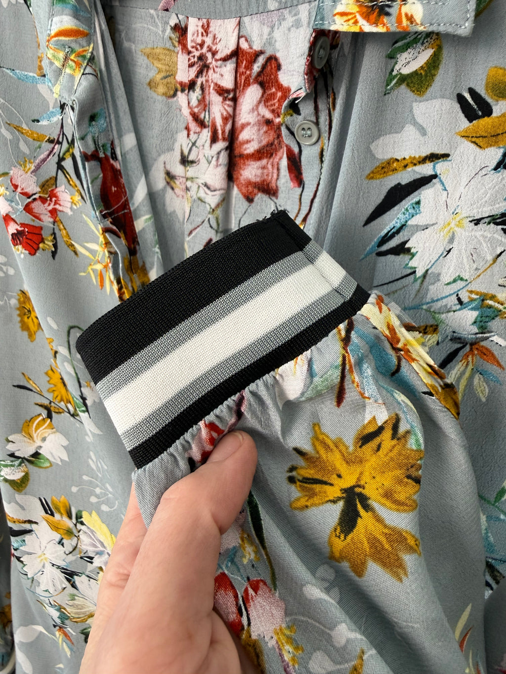 Floral fabric with a hand holding a black and white striped object