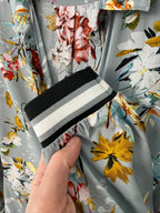Floral fabric with a hand holding a black and white striped object
