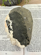back of apophyllite crystal on a book 